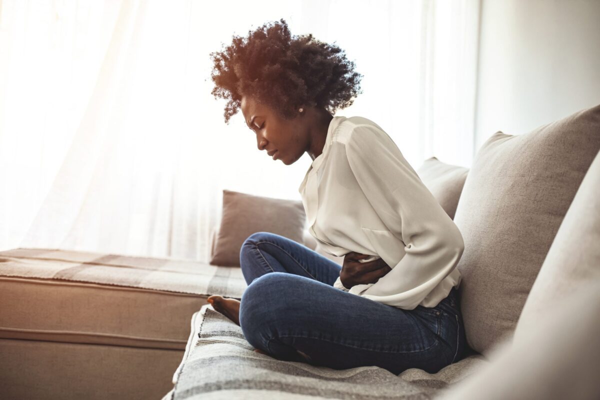 Woman lying on sofa looking sick in the living room