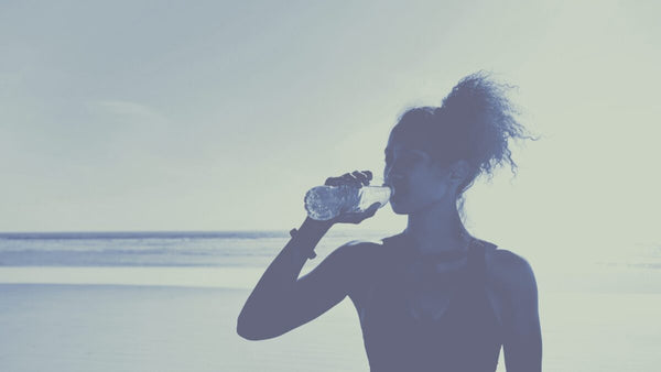 Athletic woman drinking bottle of water