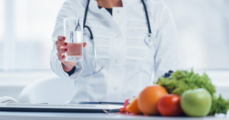 Doctor holding a clear glass of water